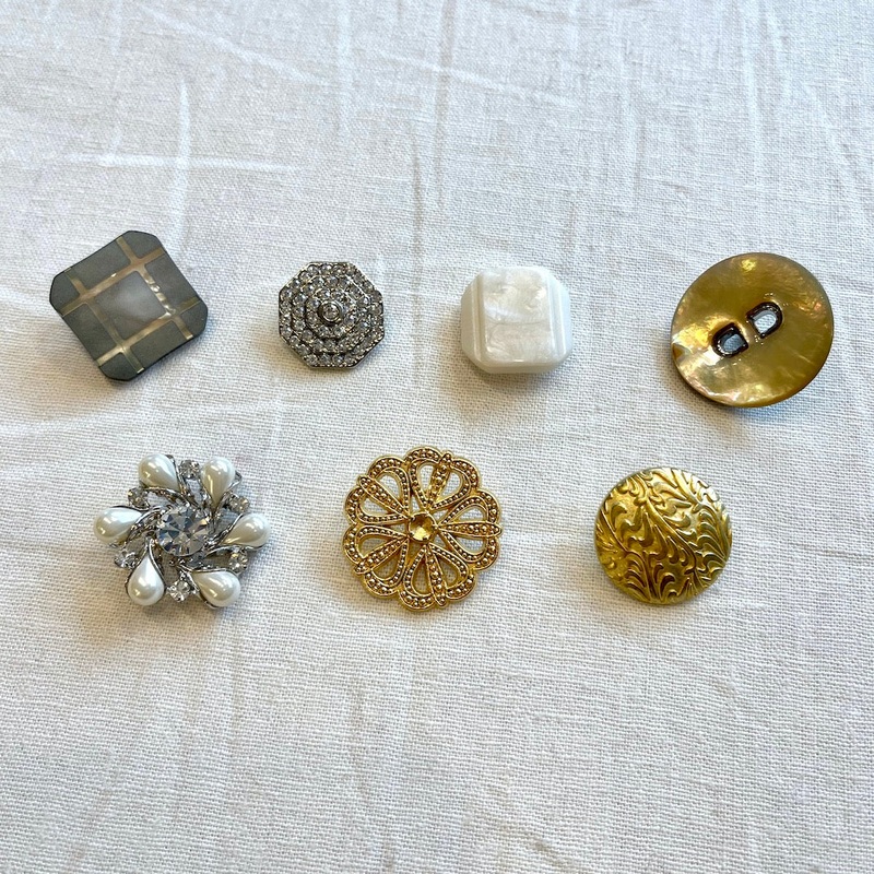 Finishing Touches: Buttons|Faux black lip oyster with grid etching, 7/8″|Rhinestone cascading octagon, 3/4″|Faux mother of pearl stepped rectangle, 7/8″|Shell with decorative center, 1 1/16″|Rhinestone and faux pearl, 1 1/8″|Goldtone decorative hearts, 1